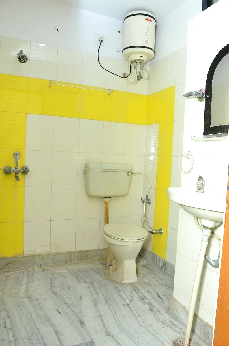 Clean attached bathroom with geyser for hot water